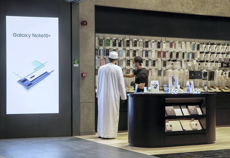 Abu Dhabi, United Arab Emirates, May 2, 2020.  Galleria Mall, Al Maryah Island reopens.  A customer looks at some mobile phones.
Victor Besa / The National
Section:  NA
Reporter: