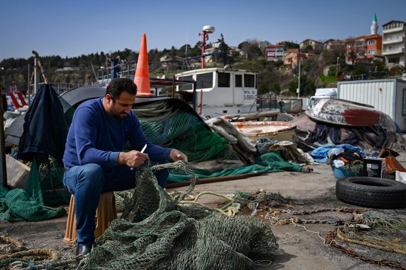 A fisherman fixes his net in Rumelifeneri, where most of the fishermen have stayed ashore since a mine was found a week ago drifting in the Black Sea a few kilometres away.