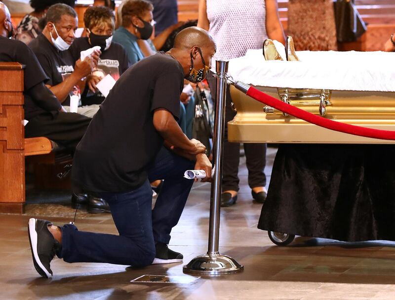 A mourner takes a knee while paying respect to Rayshard Brooks, who was shot dead June 12 by an Atlanta police officer, during a viewing a day before his funeral at Ebenezer Baptist Church in Atlanta. Reuters