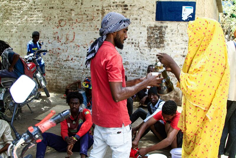 A woman serves tea to a Sudanese protester. AFP