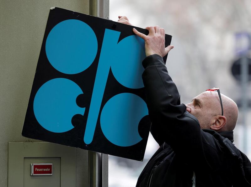 FILE PHOTO: A man fixes a sign with OPEC's logo next to its headquarters' entrance before a meeting of OPEC oil ministers in Vienna, Austria, November 29, 2017. REUTERS/Heinz-Peter Bader/File Photo