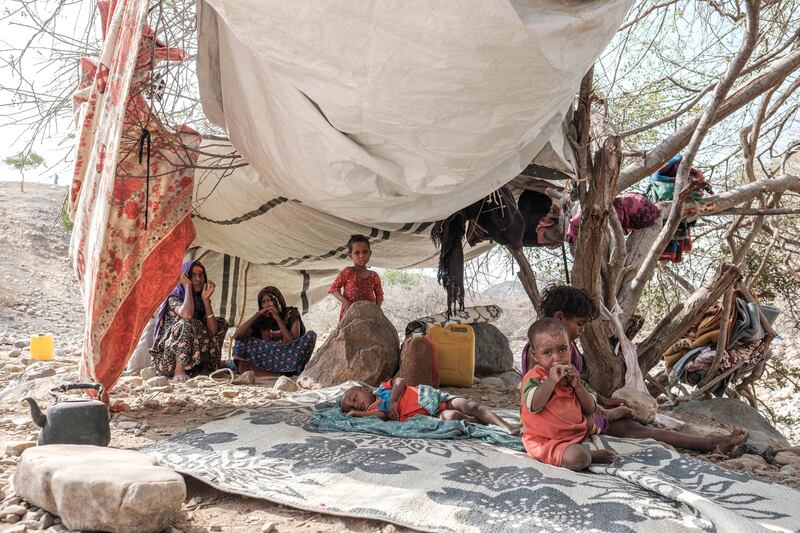 Internally displaced people sit in a tent in a makeshift camp in the village of Erebti, Ethiopia. AFP