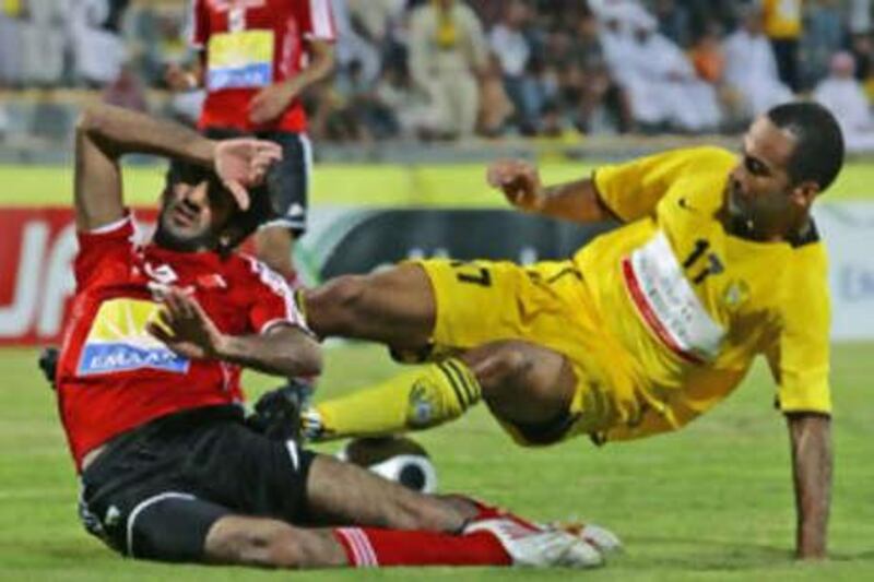 Alexander Olivira of Al Wasl, right in yellow, in action against an unidentified Al Ahli player during the UAE Pro League football tournament at Zabeel stadium.
