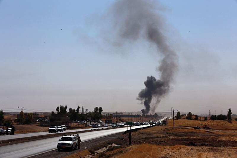 Smoke rises while Iraqi security forces use bombs as Kurdish security forces withdraw from a checkpoint in Alton Kupri, outskirts of Irbil, Iraq, Friday Oct. 20, 2017.  A Baghdad court issued an arrest warrant for the vice president of Iraq's autonomous northern Kurdish region on Thursday for saying that Iraqi forces had "occupied" the disputed province of Kirkuk this week.(AP Photo/Khalid Mohammed)