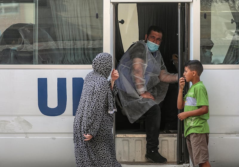 A Palestinian worker at the United Nation Relief and Works Agency distributes food aid rations for refugee families, in Gaza City. EPA