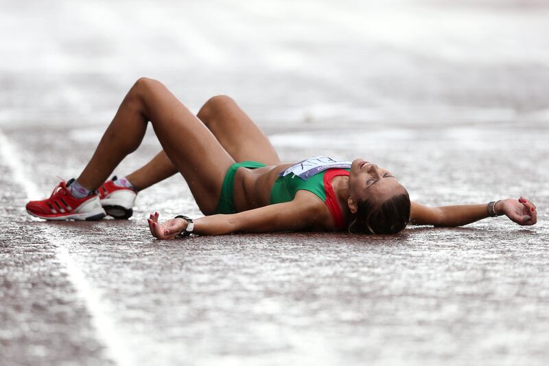 LONDON, ENGLAND - AUGUST 05:  Ana Dulce Felix of Portugal lies on the ground after crossing the finish line during the Women's Marathon on Day 9 of the London 2012 Olympic Games at The Mall on August 5, 2012 in London, England.  (Photo by Streeter Lecka/Getty Images)