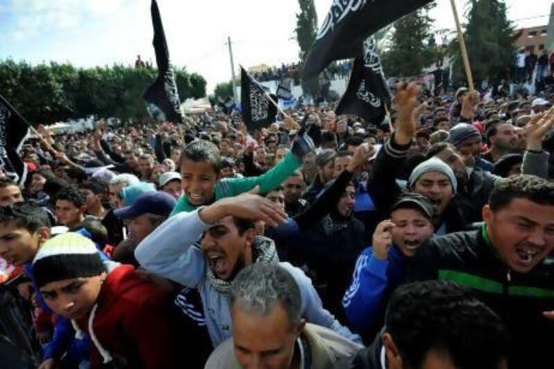 Inhabitants of Sidi Bouzid wave black religious flags and call for Tunisia's president Moncef Marzouki to leave at a rally on the second anniversary of the death of fruit seller Mohammed Bouazizi.