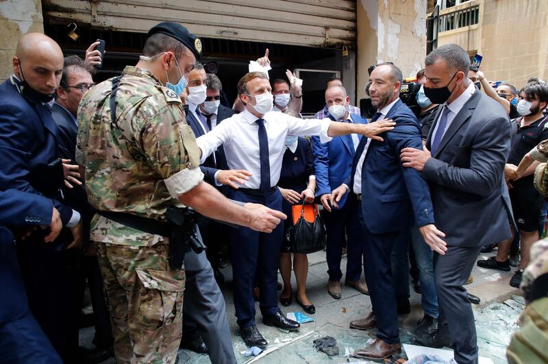 French President Emmanuel Macron gestures as he visits a devastated street of Beirut.  AFP
