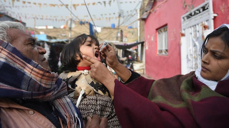 A Pakistani health worker administers polio vaccine drops to a child during a polio vaccination campaign in Islamabad in December, 2018. AFP    