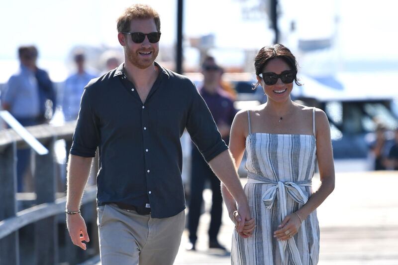 Britain's Prince Harry and his wife Meghan, the Duchess of Sussex walk to attend a meet-the-people session at Kingfisher Bay Resort on Fraser Island.  AFP
