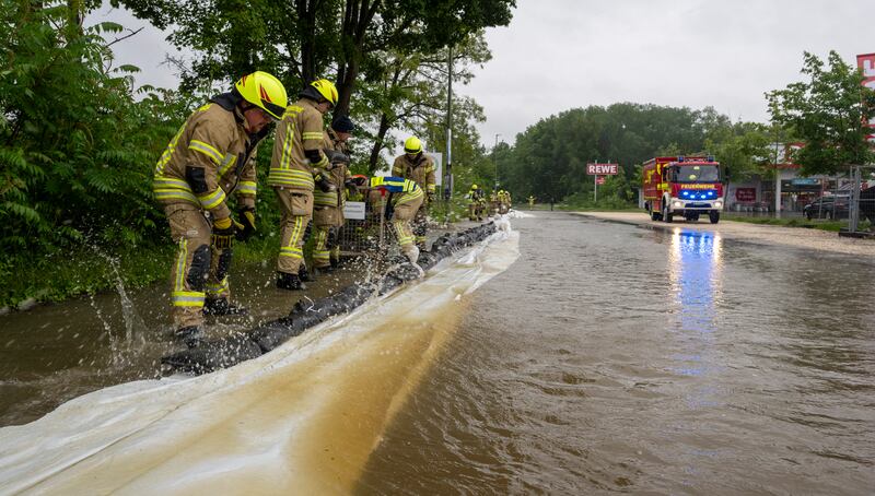 Firefighters work on a street flooded by the River Gunz in Ichenhausen, Bavaria. Weather forecasters expect more rain for Germany. AP