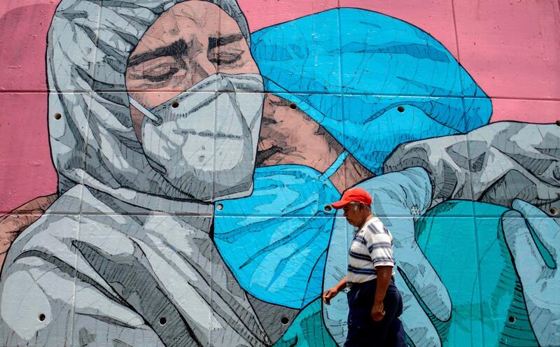A man walks past a coronavirus-related mural, in Acapulco, Guerrero State, Mexico. AFP
