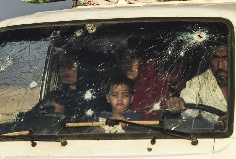 Iraqi families escape the fighting in a bullet-strewn vehicle outside Mosul. AFP 