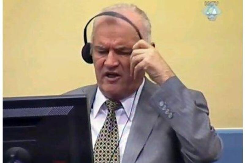 Former Bosnian Serb army chief Ratko Mladic removing his ear phones shortly before being taken from the courtroom in The Hague yesterday. Mr Mladic refused to enter a plea before a UN war crimes court. PHOTO COURTESY OF THE ICTY / AFP