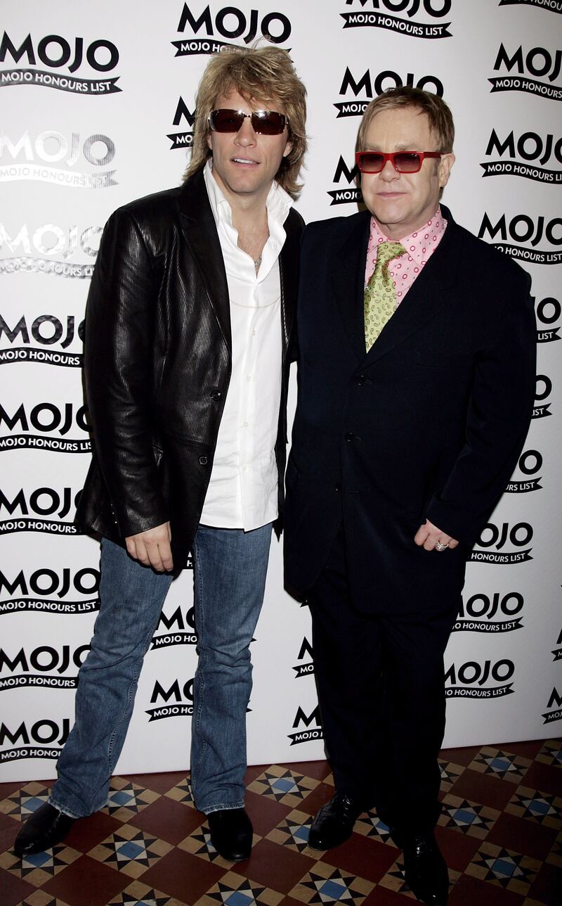 Jon Bon Jovi and Elton John, wearing a black shirt with a pink shirt and green tie, attend the Mojo Honours List awards at Shoreditch Town Hall, London on June 5, 2006. Getty Images