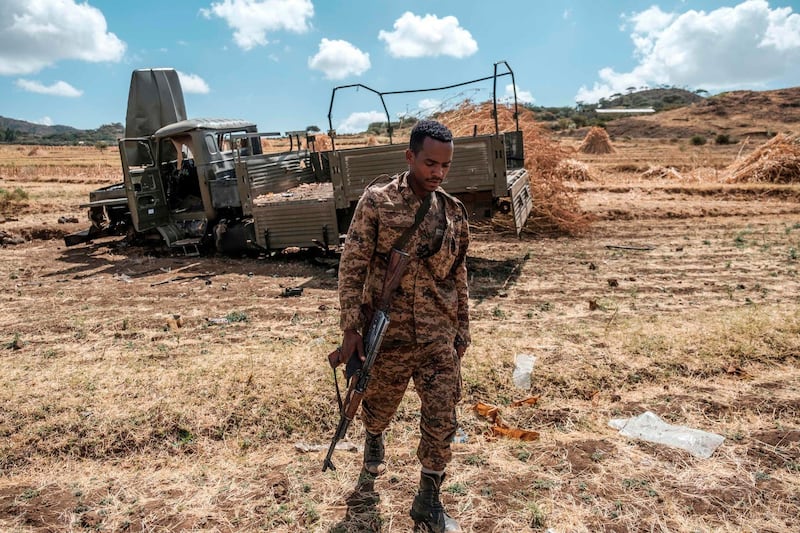 TOPSHOT - A member of the Ethiopian Defense Forces walks away from a damaged military truck abandoned on a road near the village of Ayasu Gebriel, East of the Ethiopian city of Alamata, on December 10, 2020. / AFP / EDUARDO SOTERAS
