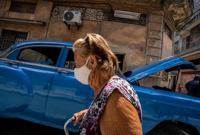 A woman, wearing a protective face mask as a precaution against the spread of the new coronavirus, walks past in Havana, Cuba, Wednesday, June 1 , 2021. (AP Photo/Ramon Espinosa)