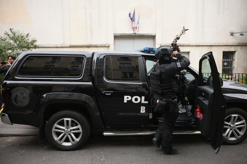 Elite police officers from the Research and Intervention Brigade leave after the operation near the Iranian consulate. AP