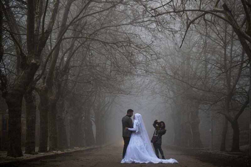 A bride and groom pose for a photo as heavy fog envelopes the village of Sawfar, Lebanon. AP Photo