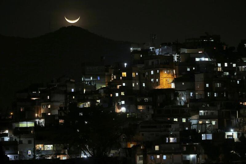 The moon is seen over a slum near Copacabana Beach in Rio. Carlos Barria / Reuters