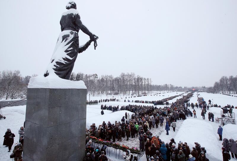 People walk in snowfall to the Motherland monument to put flowers at the Piskaryovskoye Cemetery where most of the Leningrad Siege victims were buried during World War II, in St.Petersburg, Russia. AP
