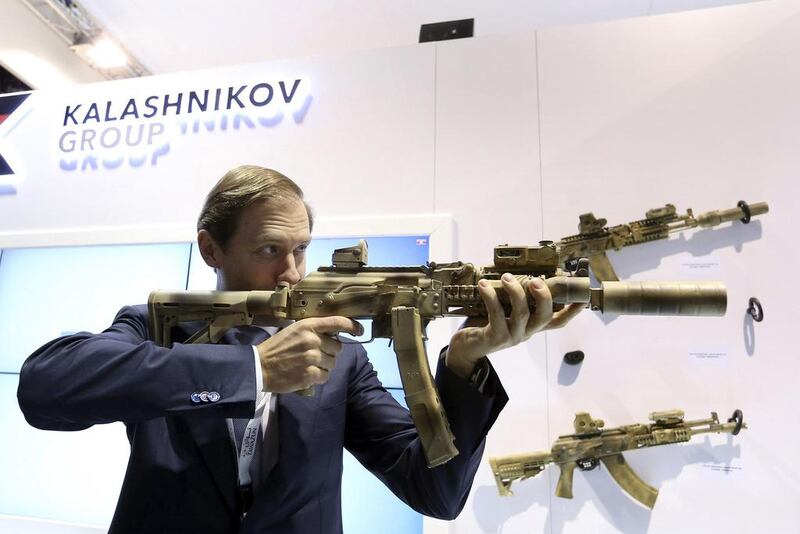 Russian trade and industry minister Denis Manturov aims a weapon during Idex 2015 in Abu Dhabi. Reuters