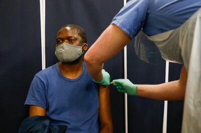 A visitor, right, receives his first dose of the AstraZeneca Plc Covid-19 vaccine in the Newham district of London, U.K., on Monday, March 22, 2021. Skepticism and misinformation are hampering efforts to protect the U.K.'s most diverse and deprived communities. Photographer: Hollie Adams/Bloomberg