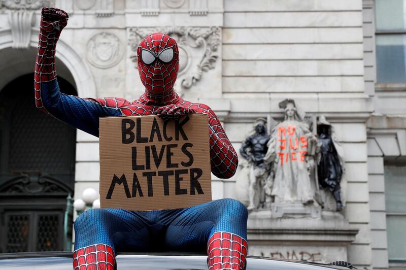 A person dressed as Spider-Man sits on a car near an area being called the "City Hall Autonomous Zone" that has been established to protest the New York Police Department and in support of "Black Lives Matter" near City Hall in lower Manhattan. Reuters