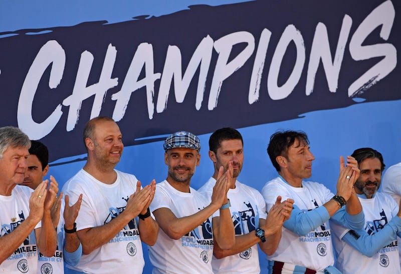 Manchester City manager Pep Guardiola, centre, stands with his coaching staff during a stage presentation.  AFP