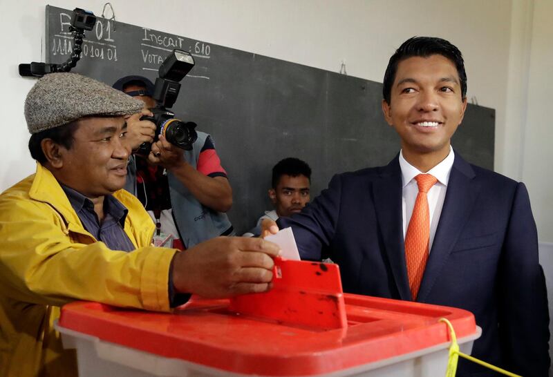 Andry Rajoelina, right, casts his ballot paper as an electoral officer looks on during a runoff presidential election in Antananarivo, Madagascar, Wednesday, Dec. 19, 2018. Voters have begun casting their ballots across the Indian Ocean island nation of Madagascar Wednesday to select a new president in a runoff election that pits two former leaders against each other.  Rajoelina, president from 2009 to 2014, received 39 percent of the vote in the first round in November, while Marc Ravalomanana, president from 2002 to 2009, got 35 percent. (AP Photo/Themba Hadebe)