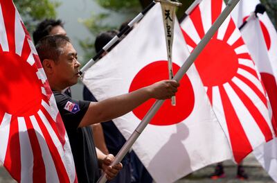 Far-right group members hold Rising Sun war flags at Yasukuni Shrine in Tokyo on Monday. EPA