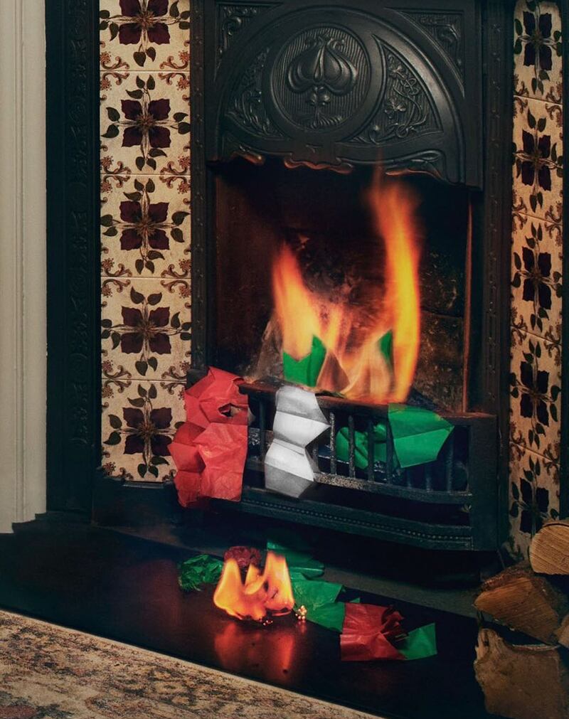 A screen grab of the M&S Instagram post, showing red, green and silver Christmas hats burning in a grate. PA