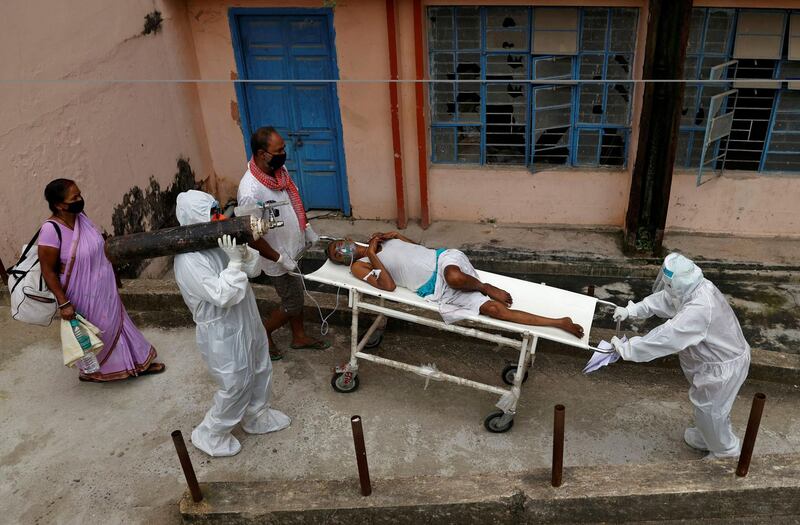 A medical workercarries an oxygen cylinder on his shoulder as Covid-19 patient is transferred from the emergency ward to the intensive care unit of Jawahar Lal Nehru Medical College and Hospital in Bhagalpur, India. Reuters