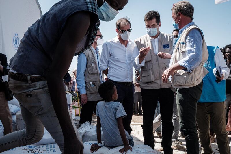 Janez Lenarcic (2nd-R), European Commissioner for Crisis Management, visits a warehouse erected by the World Food Programme (WFP) at Um Raquba reception camp for Ethiopian refugees who fled the Tigray conflict, in Sudan's eastern Gedaref state on December 3, 2020. - More than 45,000 people have escaped from northern Ethiopia since November 4, after Prime Minister Abiy Ahmed ordered military operations against leaders of Tigray's ruling party in response to its alleged attacks on federal army camps. (Photo by Yasuyoshi CHIBA / AFP)