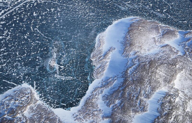 IN FLIGHT, GREENLAND - MARCH 27:  Sea ice (TOP) meets land as seen from NASA's Operation IceBridge research aircraft along the Upper Baffin Bay coast on March 27, 2017 above Greenland. Greenland's ice sheet is retreating due to warming temperatures. NASA's Operation IceBridge has been studying how polar ice has evolved over the past nine years and is currently flying a set of eight-hour research flights over ice sheets and the Arctic Ocean to monitor Arctic ice loss aboard a retrofitted 1966 Lockheed P-3 aircraft. According to NASA scientists and the National Snow and Ice Data Center (NSIDC), sea ice in the Arctic appears to have reached its lowest maximum wintertime extent ever recorded on March 7. Scientists have said the Arctic has been one of the regions hardest hit by climate change.  (Photo by Mario Tama/Getty Images)