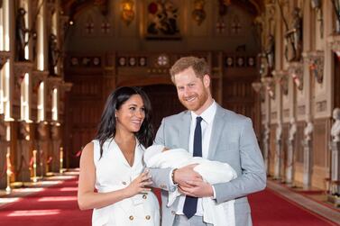 Britain's Prince Harry, Duke of Sussex (R), and his wife Meghan, Duchess of Sussex, pose for a photo with their newborn baby son in St George's Hall at Windsor Castle in Windsor, west of London on May 8, 2019. / AFP / POOL / Dominic Lipinski