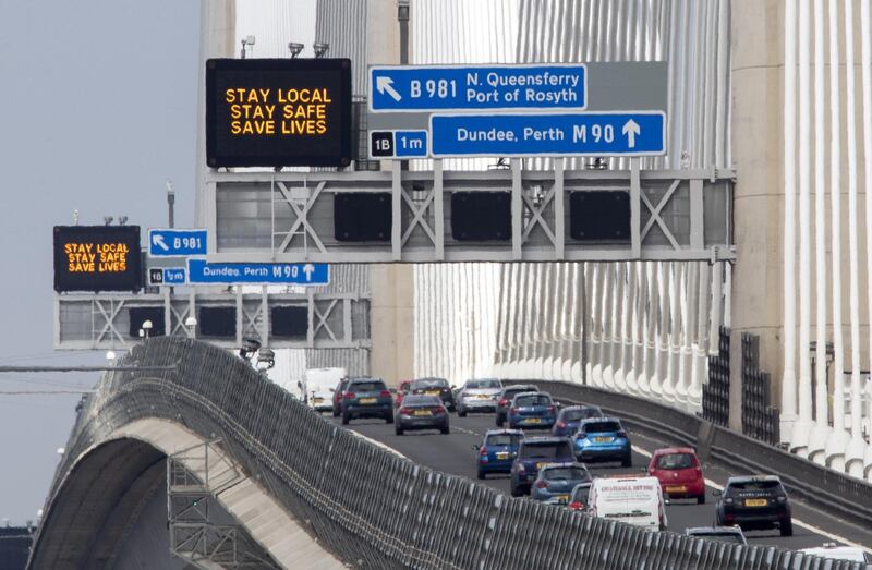 Traffic information signs read "Stay Local, Stay Safe, Save Lives" above the M90 on the Queensferry Crossing near Edinburgh following the easing of Scotland's lockdown restrictions to allow far greater freedom outdoors. Picture date: Friday April 2, 2021. (Photo by Jane Barlow/PA Images via Getty Images)