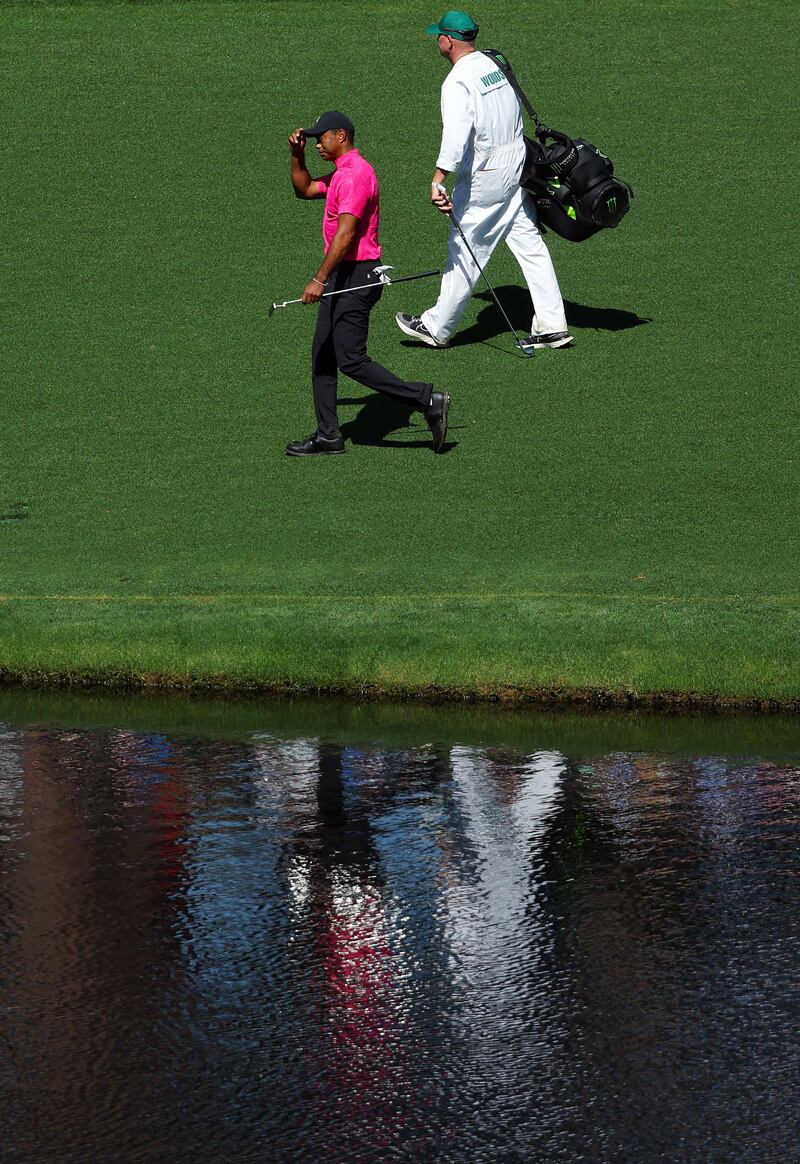 Woods acknowledges the fans while walking across the 16th hole. AFP