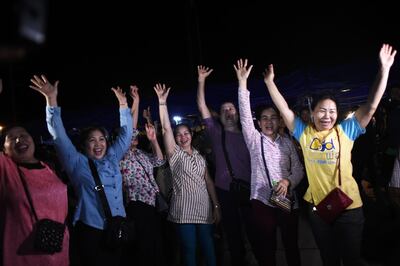 TOPSHOT - Volunteers celebrate at a makeshift press centre in Mae Sai district of Chiang Rai province on July 10, 2018, after the twelve boys and their football coach were rescued. The final five members of a young football team were rescued from a flooded Thai cave on July 10, after spending 18 harrowing days trapped deep inside, completing an astonishing against-the-odds rescue mission that captivated the world. / AFP / Ye Aung THU
