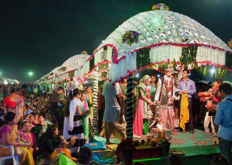 Indian brides and grooms seen during a mass wedding of 111 fatherless women in Surat, some 265 kms from Ahmedabad, on November 30, 2014. An Indian diamond trader Mahesh Savani paid for their weddings. AFP Photo