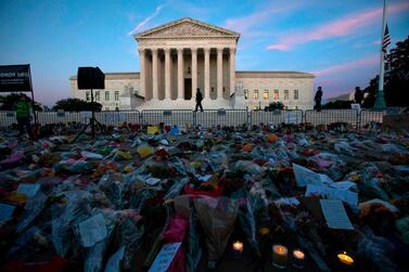 Flowers, candles, and signs are pictured at a makeshift memorial outside of the US Supreme Court as people pay their respects to Ruth Bader Ginsburg in Washington, DC on 19 September. Jose Luis Magana / AFP