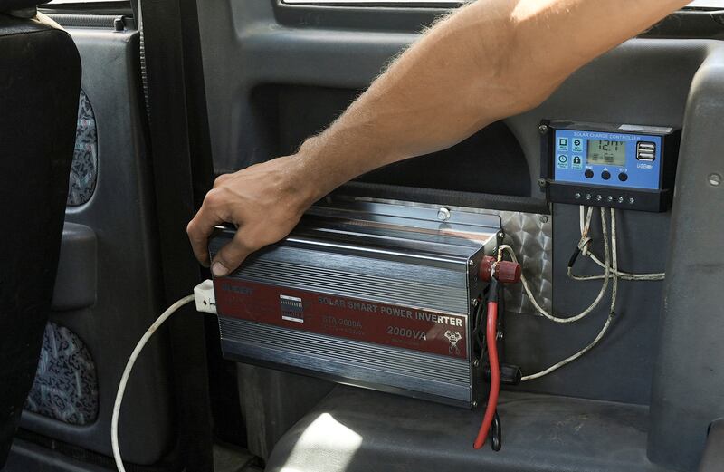 Mr Al Safadi switches on a solar smart power inverter inside the car.