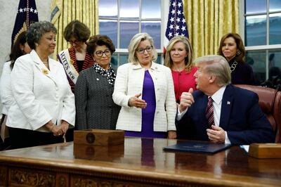 FILE - In this Nov. 25, 2019, file photo, Rep. Liz Cheney, R-Wyo., center, speaks with President Donald Trump during a bill signing ceremony for the Women's Suffrage Centennial Commemorative Coin Act in the Oval Office of the White House in Washington. Trump and his supporters are intensifying efforts to shame members of the party who are seen as disloyal to the former president and his false claims that last yearâ€™s election was stolen from him.(AP Photo/Patrick Semansky, File)