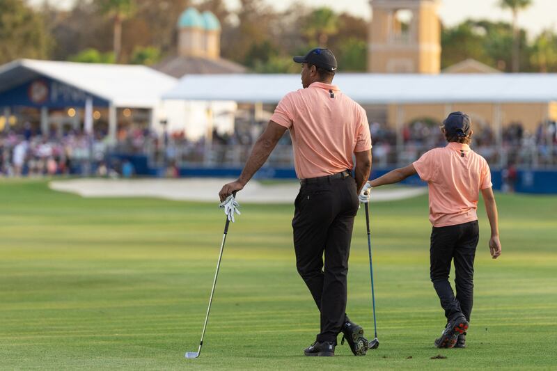 Tiger Woods and son Charlie Woods wait to  play their shot on the 18th fairway. USA Today