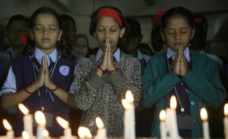 India schoolgirls in Mumbai offer prayers for victims killed in a Taliban attack on a military-run school in Peshawar. Rafiq Maqbool / AP Photo