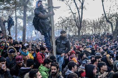 TOPSHOT - Migrants gather inside the buffer zone of the Turkey-Greece border, at Pazarkule, in Edirne district, on February 29, 2020. Thousands of migrants stuck on the Turkey-Greece border clashed with Greek police on February 29, 2020, according to an AFP photographer at the scene. Greek police fired tear gas at migrants who have amassed at a border crossing in the western Turkish province of Edirne, some of whom responded by hurling stones at the officers. The clashes come as Greece bolsters its border after Ankara said it would no longer prevent refugees from crossing into Europe following the death of 33 Turkish troops in northern Syria. / AFP / BULENT KILIC