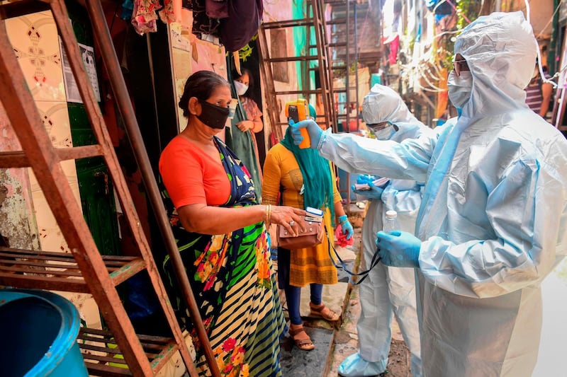 Medical staff wearing personal protective equipment conduct a door-to-door medical screening inside the Dharavi slums. AFP