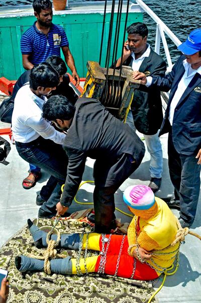 In this photo taken on June 16, 2019 Indian stuntman Chanchal Lahiri, known by his stage name "Jadugar Mandrake", is prepared for being lowered into the Ganges river, while tied up with steel chains and ropes, in Kolkata. An Indian magician who went missing after being lowered into a river tied up in chains and ropes in a Houdini-inspired stunt is feared drowned, police said June 17.
 / AFP / STR
