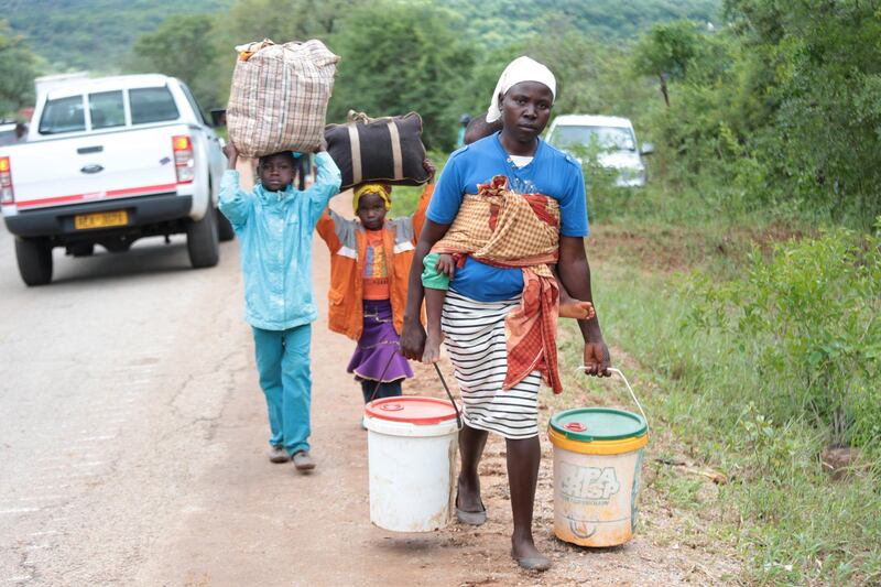 A woman and her children carry some of their belongings after their village was destroyed in Chimanimani, Zimbabwe. EPA