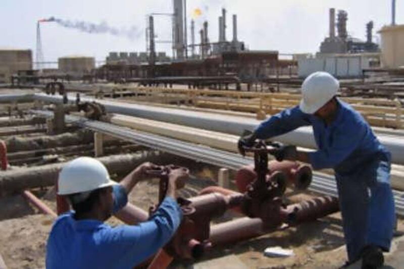 Iraqi workers operate the valves at the oil fields of Rumailah, near the southern city of Basra.